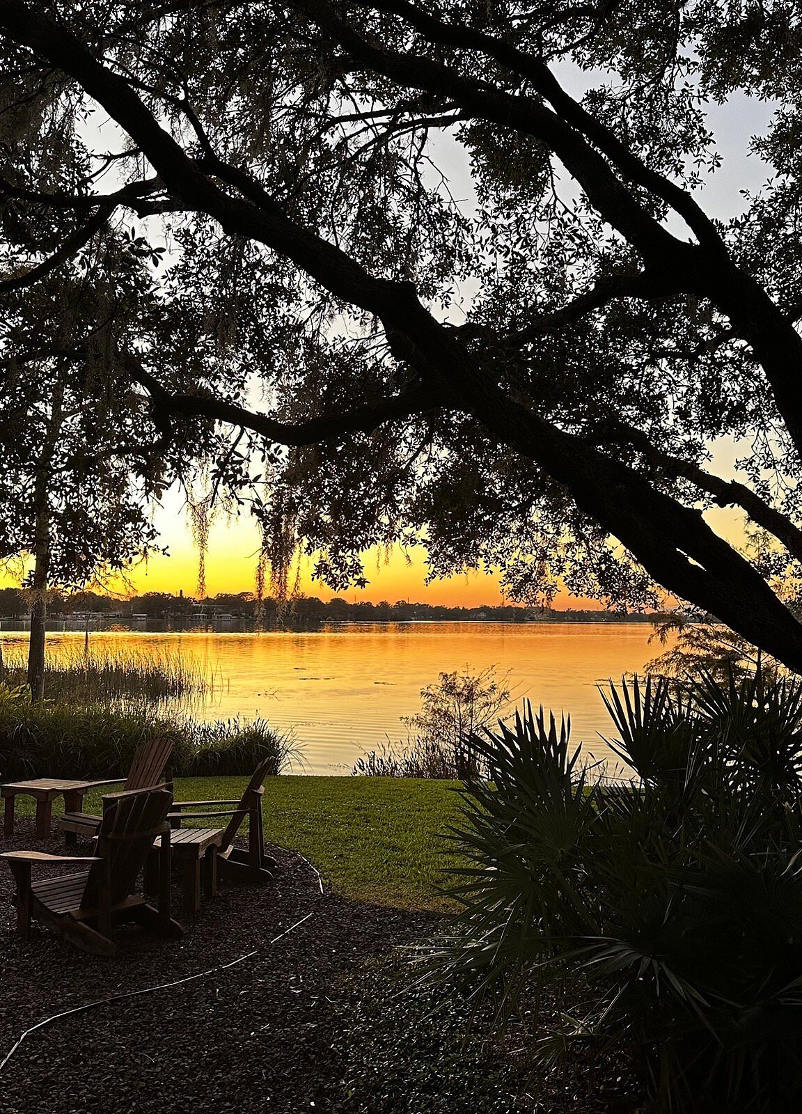 Chairs beside a lake at sunset